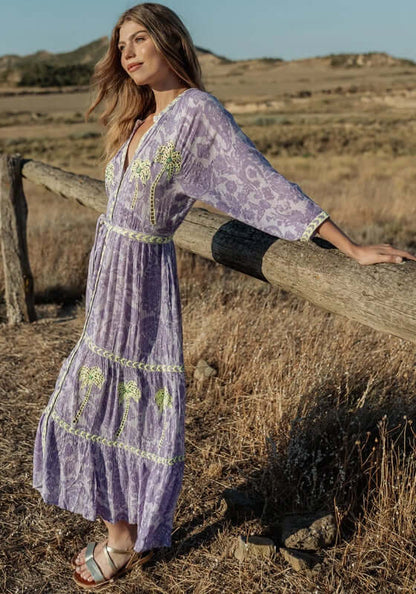 Sahara Purple Long Dress by Piti Cuiti, a beautiful model wearing a flowy purple maxi dress in a natural setting.