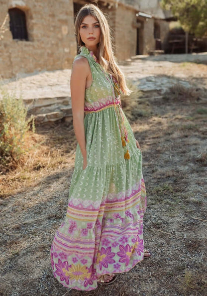 Curacao Dress Green by Piti Cuiti, a flowy maxi dress with ruffled collar and tiered skirt in vibrant pink and green patterns.