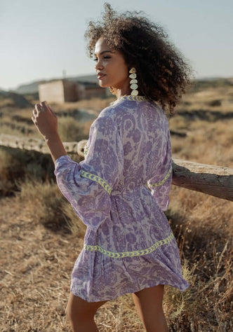 Sahara Purple Dress by Piti Cuiti, showcasing a model wearing a striking purple dress with vibrant embroidery in a natural setting.