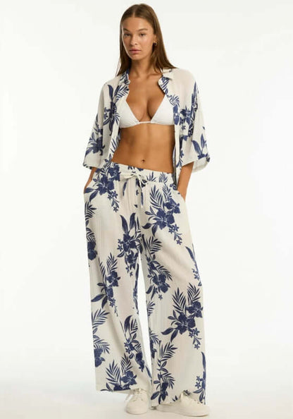 Aloha Beach Trousers Ivory by Sea Level, featuring a model in ivory trousers with navy floral print and a bikini top.