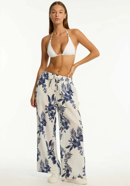 Aloha Beach Trousers Ivory by Sea Level, featuring a model in a bikini and floral white trousers with a drawstring waist.