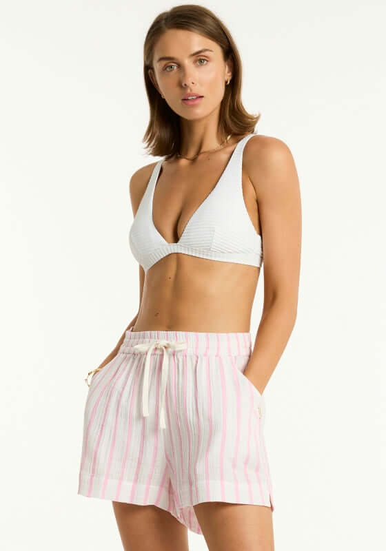 Amalfi Beach Shorts Pink by Sea Level, featuring a model wearing loose fit pink and white striped shorts with side pockets.