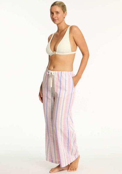 Boho Stripe Beach Trousers Blue by Sea Level, featuring a model wearing wide leg trousers with a drawstring waist and side pockets.