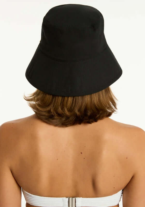 Canvas Bucket Beach Hat Black by Sea Level worn from behind, showcasing the stylish foldable design in black.