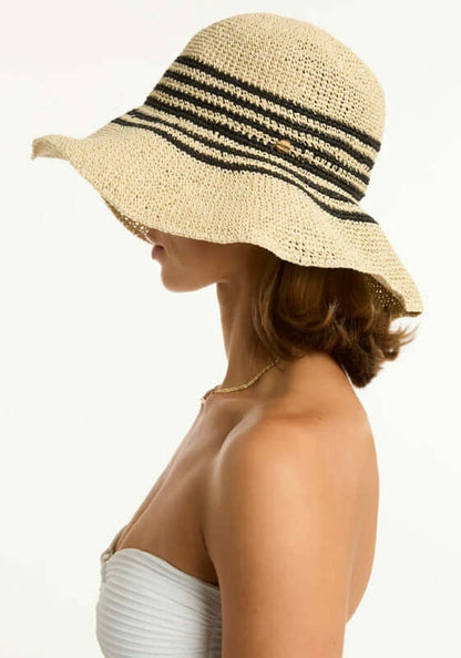 Profile view of a woman wearing a Gili Beach Hat, showcasing its stylish black stripes and foldable design.