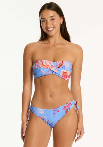 Indochine Twist Bandeau Bikini Light Blue by Sea Level worn by a model, featuring a twist-front bandeau top and tie-side bottoms.
