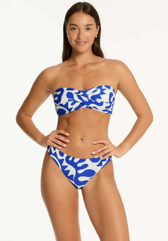 Seascape Twist Bandeau Bikini by Sea Level model wearing stylish blue and white patterned bikini with soft cup support.
