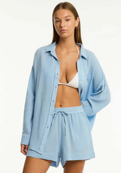 Sunset Beach Shirt Cornflower Blue by Sea Level, model wearing a light blue shirt with a bikini, perfect for sunny days.