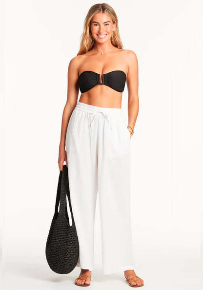 Sunset Beach Trousers White by Sea Level model wearing breathable white pants with side pockets and drawstring waist.