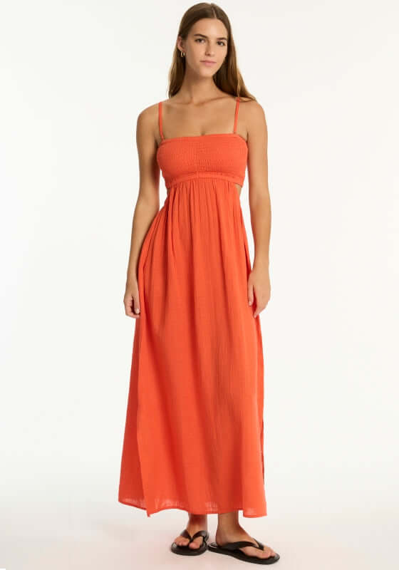 Sunset Bandeau Dress Flame by Sea Level model wearing red flame beach dress with shirred bust and flowy skirt.