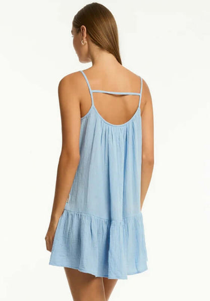 Sunset Short Sundress Cornflower Blue by Sea Level, featuring a back view of a woman in a light blue tiered sundress.
