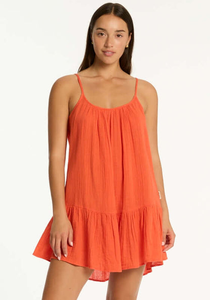 Sunset Short Beach Dress Flame by Sea Level, a model wearing a red flame beach dress in a breezy silhouette.
