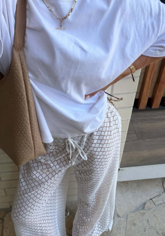 Drawstring Lace Beach Trousers White by Seafolly modeled with a casual white t-shirt and bag, showcasing relaxed beach style.