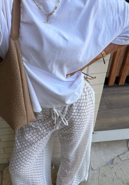 Drawstring Lace Beach Trousers White by Seafolly modeled with a casual white t-shirt and bag, showcasing relaxed beach style.
