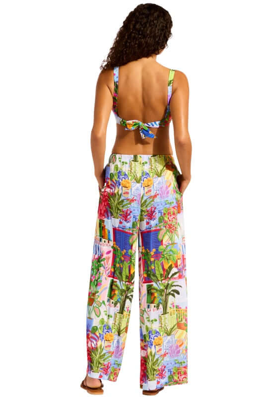 La Boca Wide Leg Beach Trousers by Seafolly shown on a model wearing a vibrant floral print ensemble with a tied-back top.