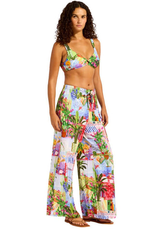 La Boca Wide Leg Beach Trousers by Seafolly featuring a vibrant floral pattern, worn by a model at the beach.
