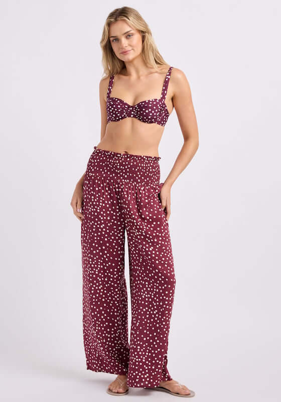 Dolce Dot Shirred Waist Beach Trouser by Seafolly, model wearing burgundy trousers with white polka dots.