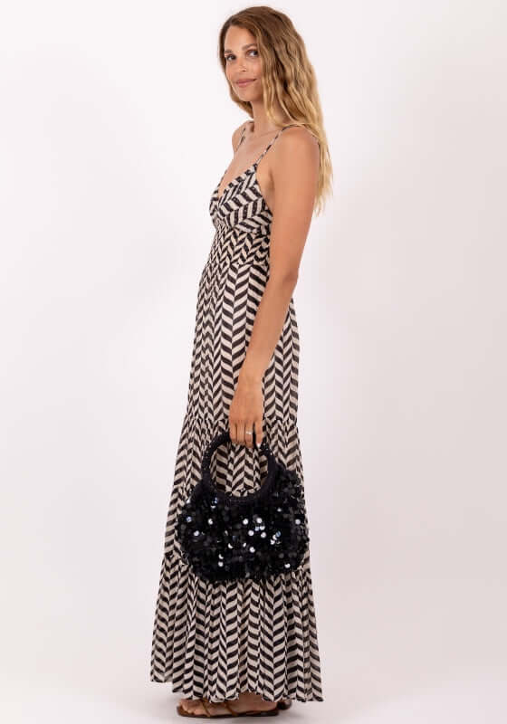 Ditta Dress Black and White by Sundress featuring a model with side profile holding a black sequined handbag.