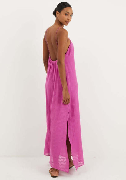 Lily Long Dress French Rose by Vix, showcasing a model in a pink maxi beach dress with open back and side slits.